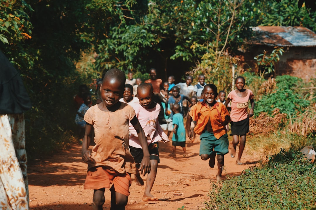 children-running-and-walking-on-brown-sand-surrounded-with-trees-during-daytime-zf9-yiaekjs
